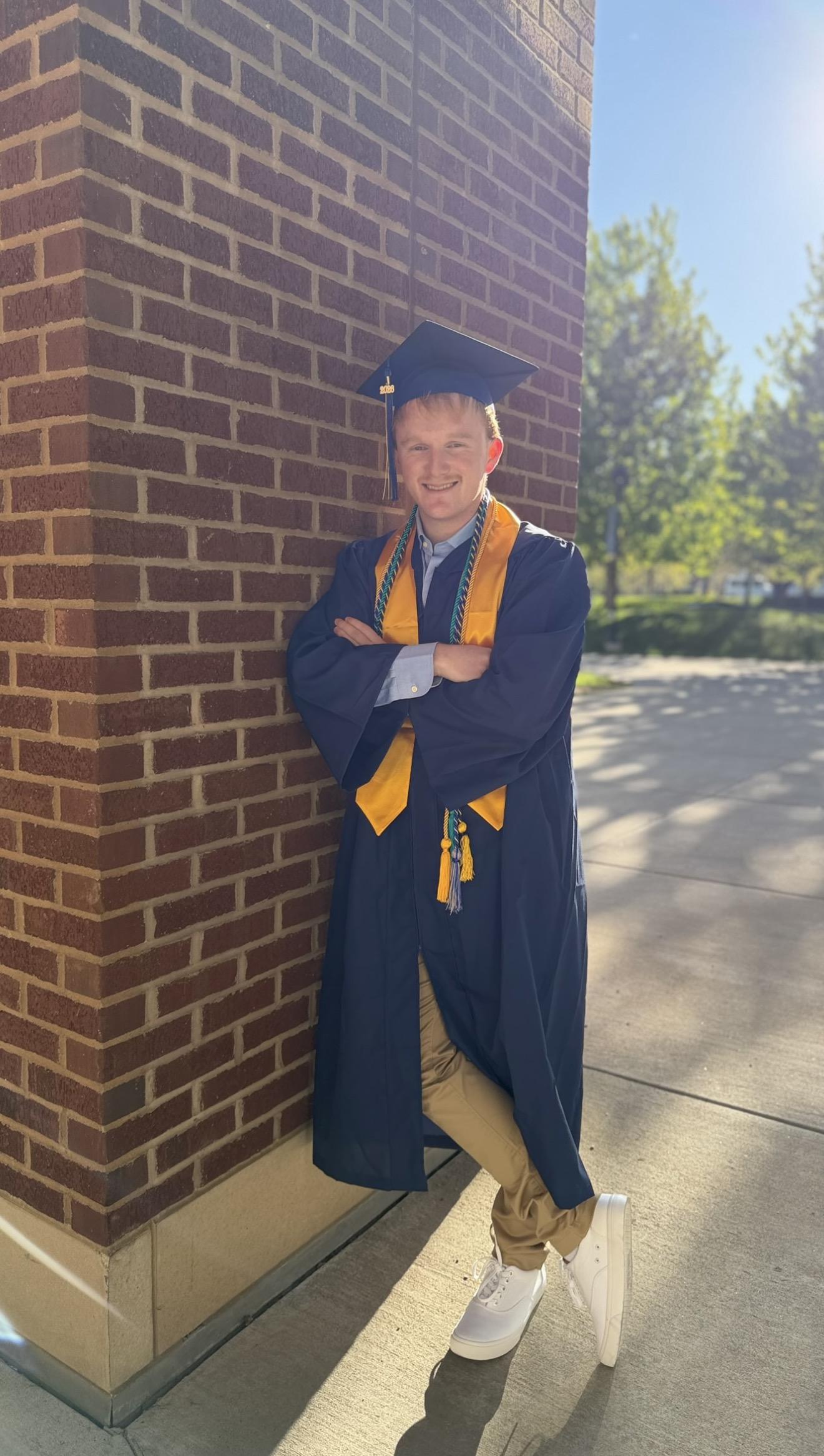 Graduation portrait outside a brick campus building